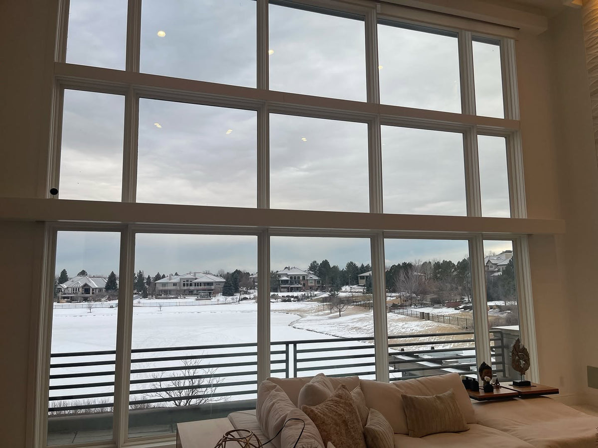 Living room with large windows showing a snowy landscape tinted with Turbo Tint for no need of blinds or curtains